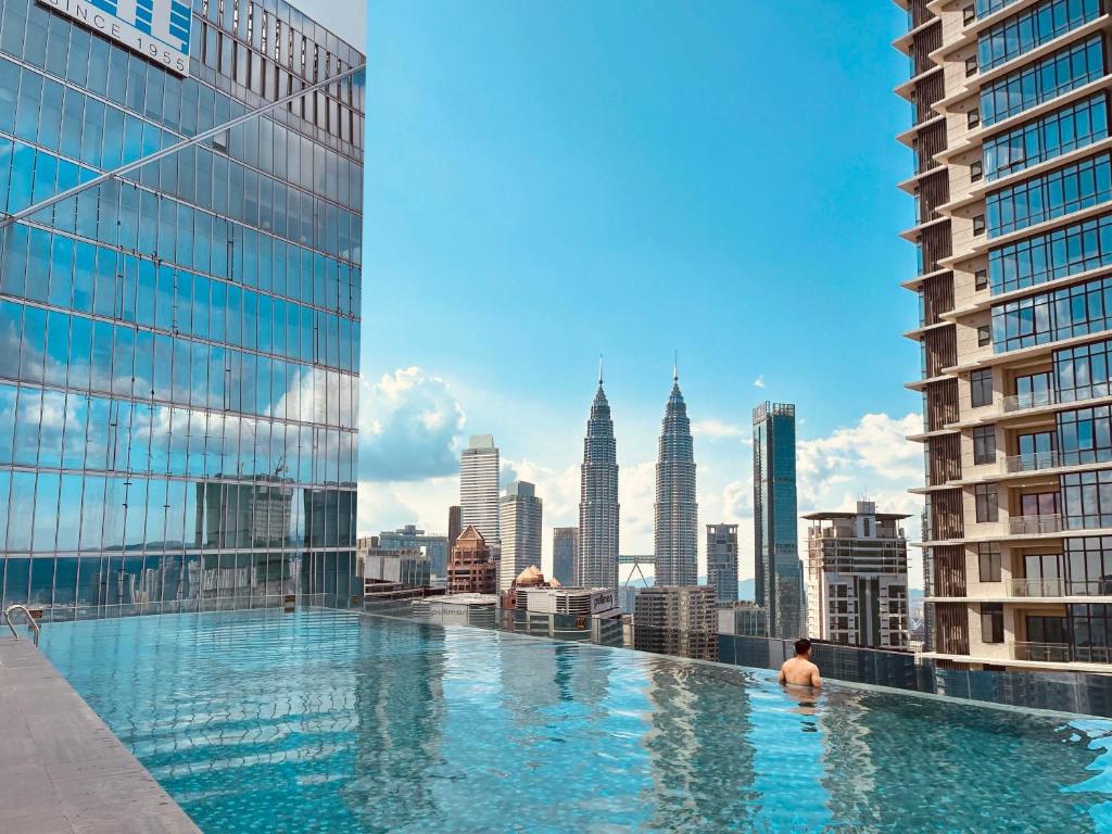a man in a swimming pool on top of a building at Crystal Suite at Dorsett Bukit Bintang KL in Kuala Lumpur