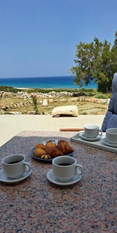 two cups of coffee and pastries on a table near the beach at Mitato's Horizon in Akrotiri
