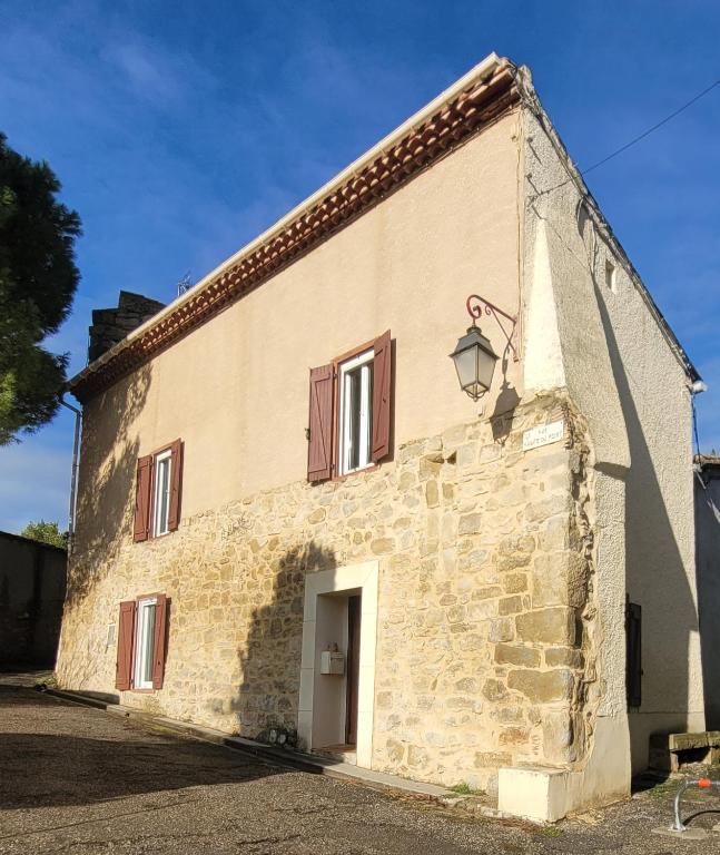 - un vieux bâtiment en pierre avec une porte et une fenêtre dans l'établissement Le Gîte du Fort, à Saint-Hilaire