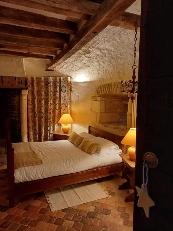 - une chambre avec un lit et deux lampes dans l'établissement Maison d hôtes du chateau de Bouesse, à Bouesse