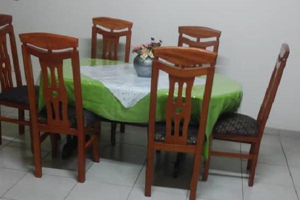 Una mesa de comedor con cuatro sillas y un mantel verde. en LIKARLELoc, en Edéa