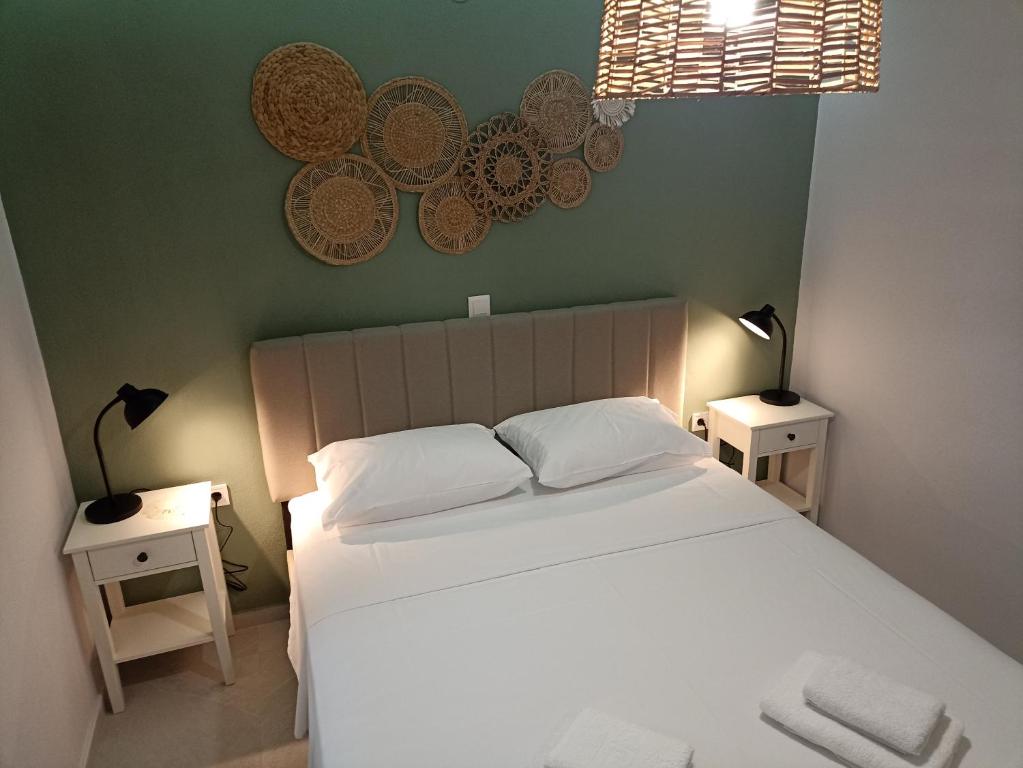 a bedroom with a white bed with two tables and two lamps at Dimitros Apartment II in Neos Marmaras