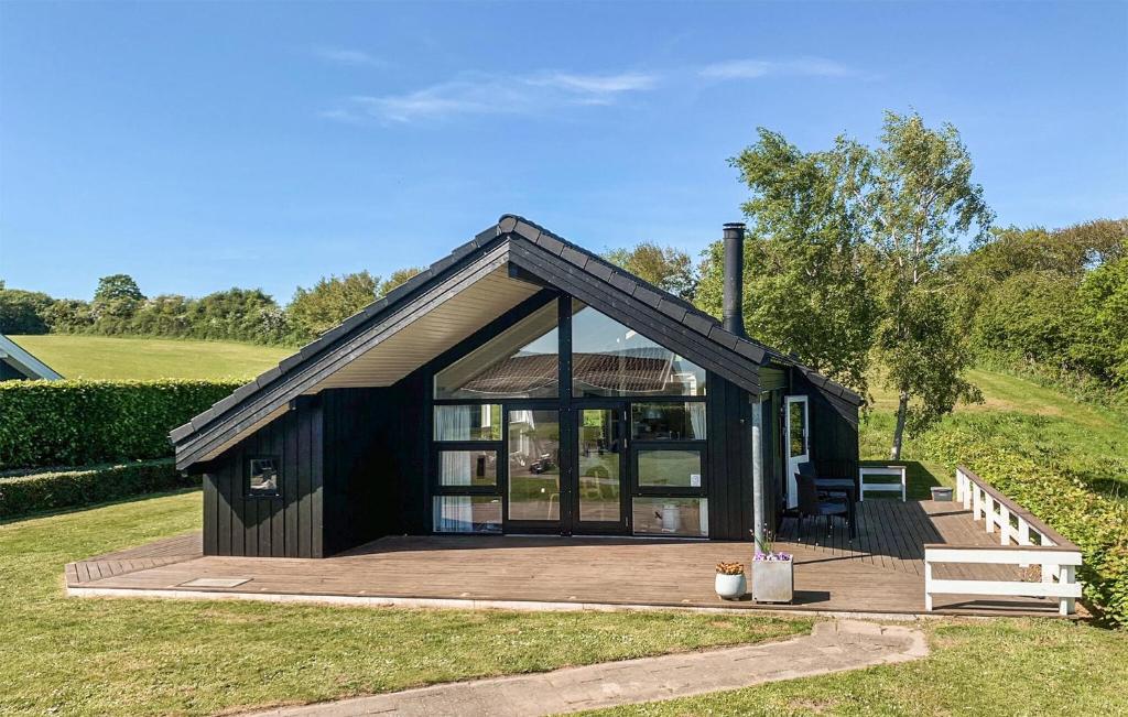 una piccola casa con un grande ponte in un campo di Holiday Home Trappendalvej Hejls a Hejls