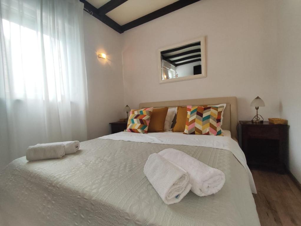 sypialnia z dużym białym łóżkiem z ręcznikami w obiekcie Apartment Astoria w mieście Krilo