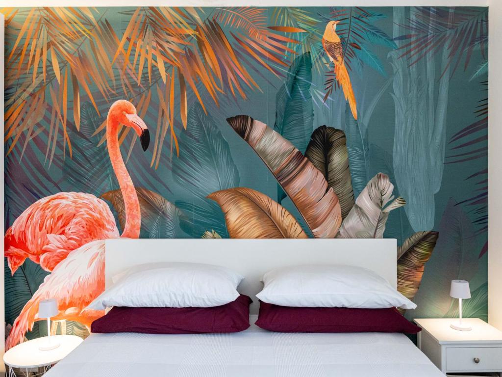 a bedroom with a flamingo wall mural at Elegante a due passi dal mare in Alassio