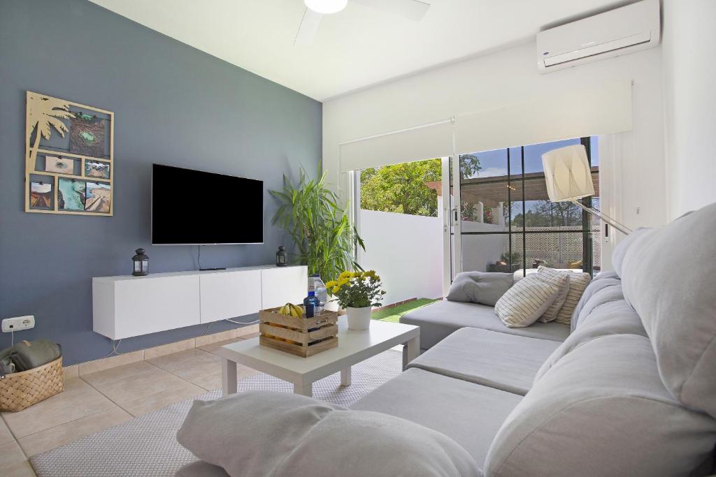 a living room with a couch and a tv at Apartamento 104 in Caleta De Fuste