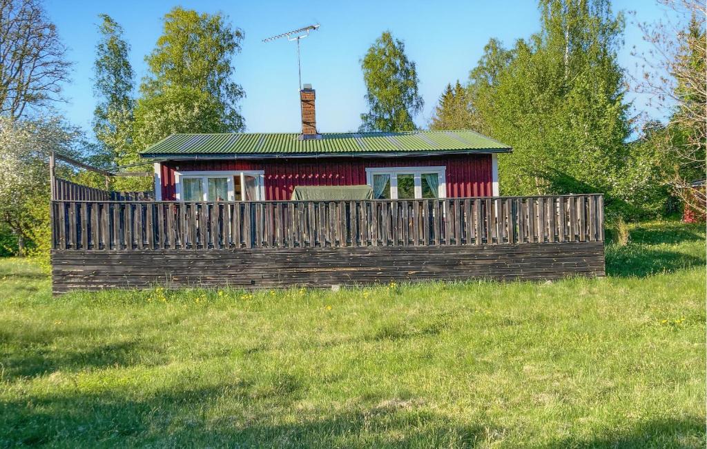 a small house with a wooden fence in a field at 1 Bedroom Amazing Home In Väddö in Väddö
