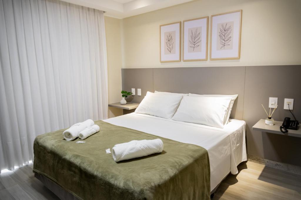 1 dormitorio con 1 cama con 2 toallas en Augusta Hotel en João Neiva