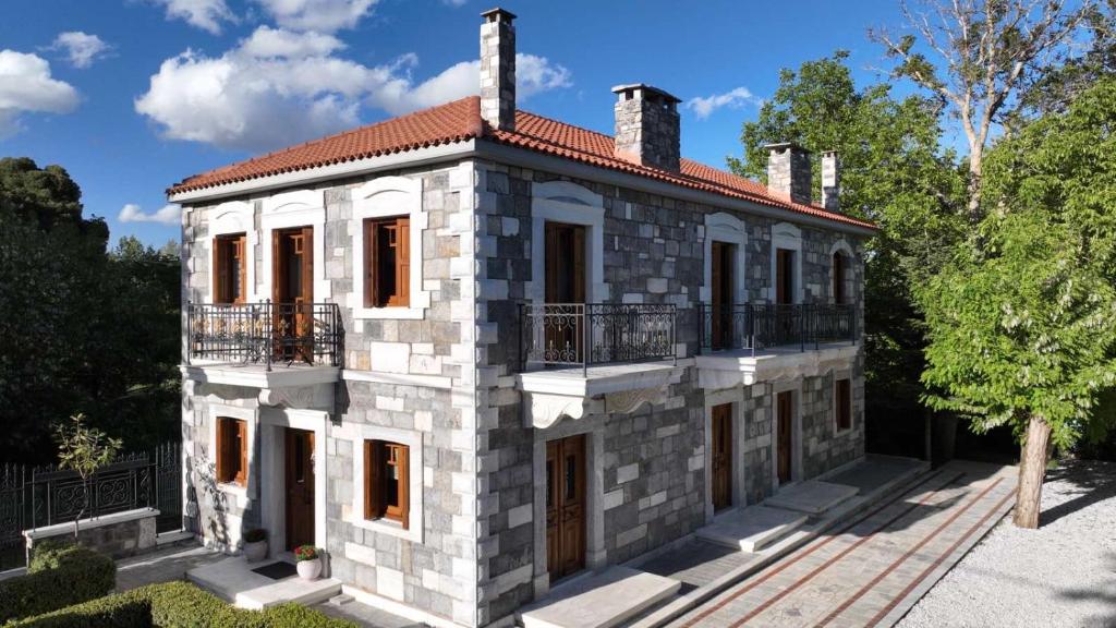an old stone house with a balcony on the side at ΤΕΓΟΣ Country Guest House in Tripolis