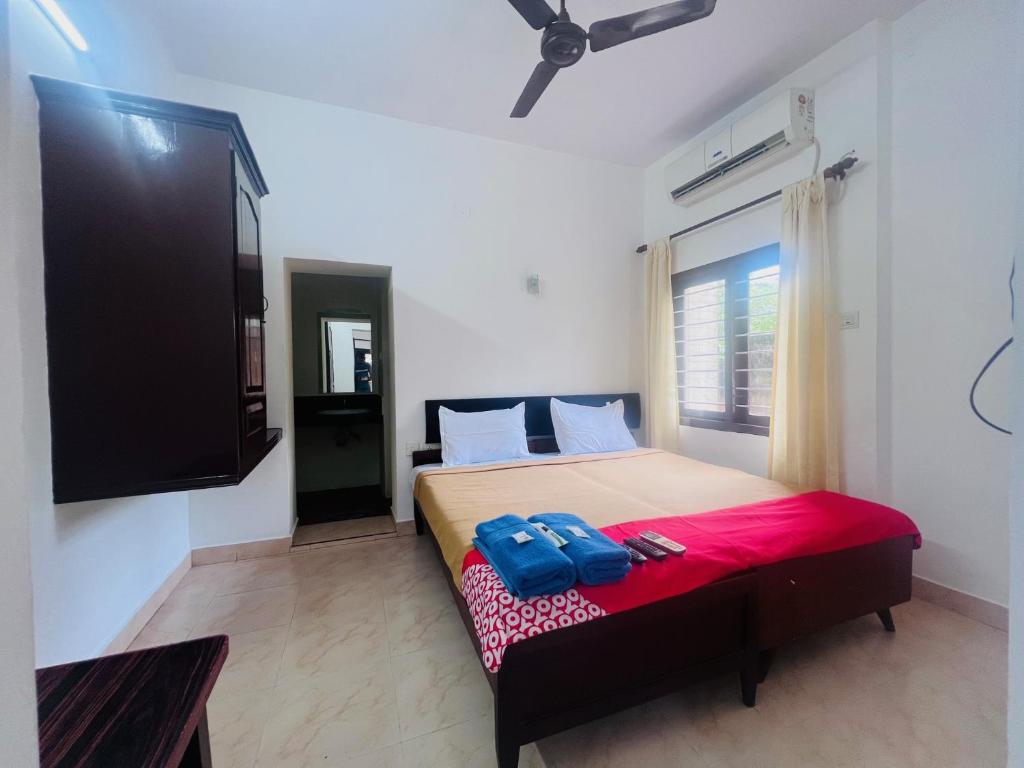 a bedroom with a bed and a flat screen tv at Hotel Sunday - Townhouse Club Airport Trivandrum in Trivandrum