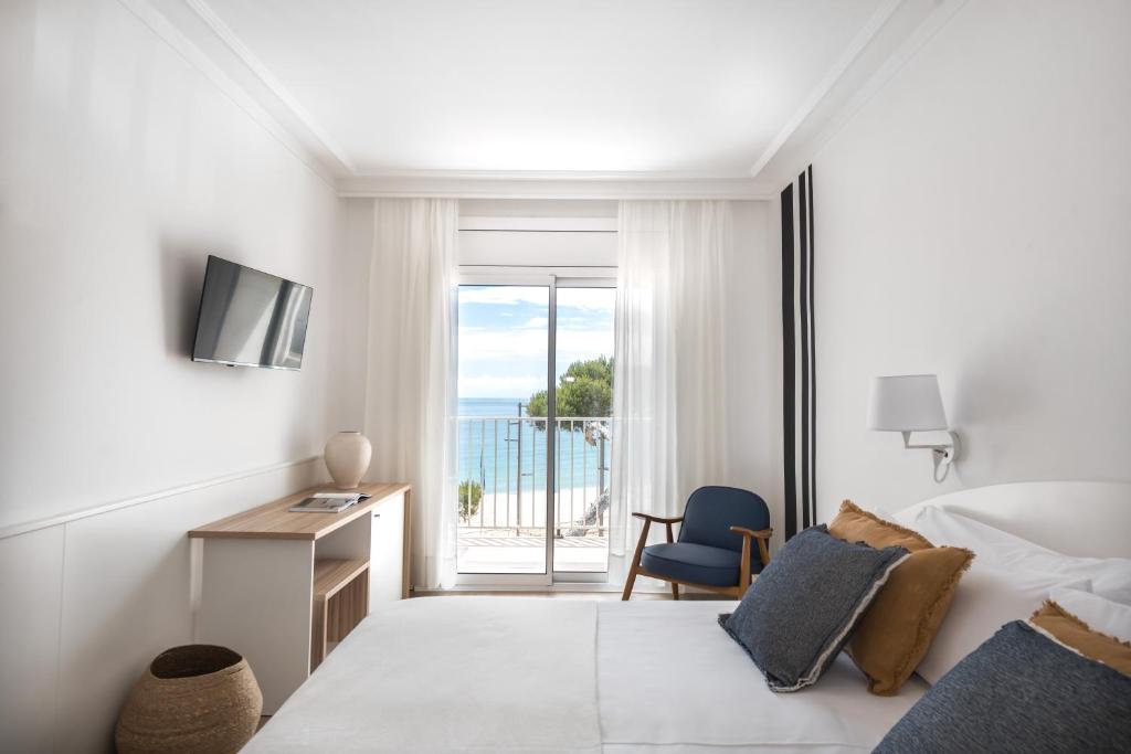 a bedroom with a bed and a view of the ocean at Hotel Terramar in Llafranc