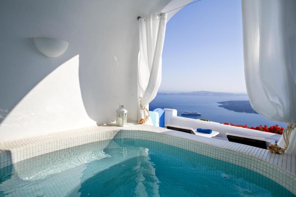 a swimming pool with a view of the water at Dreams Luxury Suites in Imerovigli