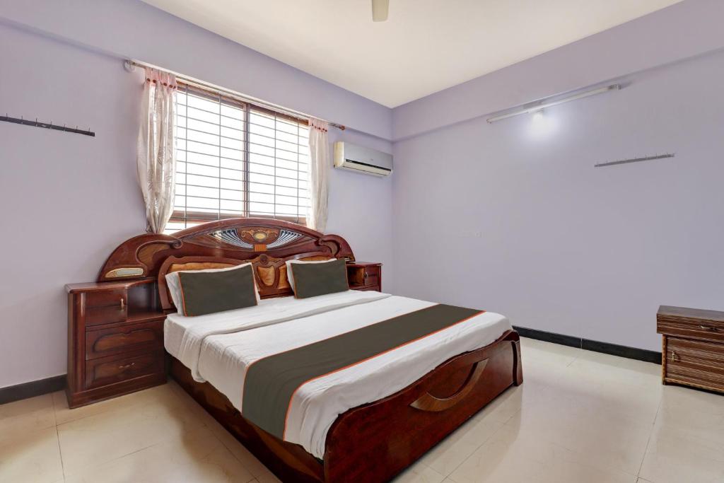 1 dormitorio con cama grande de madera y ventana en Collection O KMM Kushi Resort, en Gundlupet