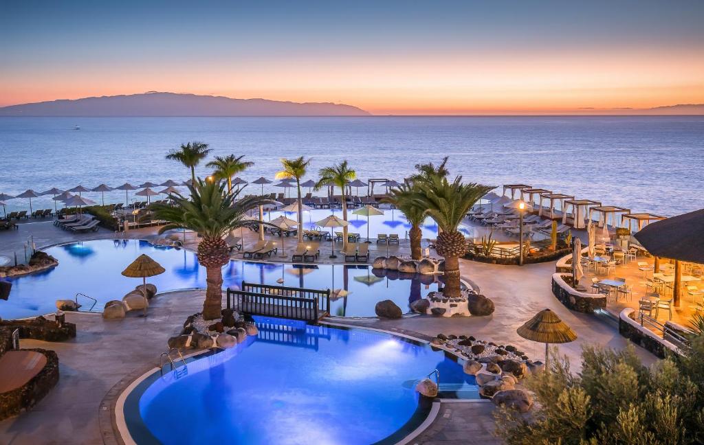 プエルト・デ・サンティアゴにあるBarceló Santiago - Adults Onlyのプールと海を望むリゾートです。
