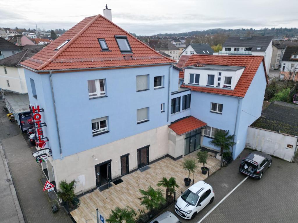 una gran casa blanca con techo rojo en Hotel Bruchsaler Herz en Bruchsal