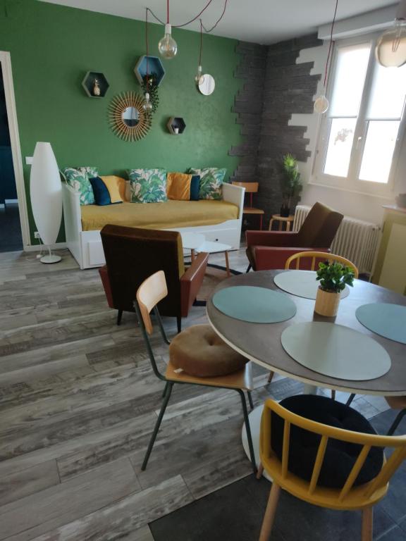a living room with two tables and a couch at Gîte, le Colmar Vintage Station in Colmar
