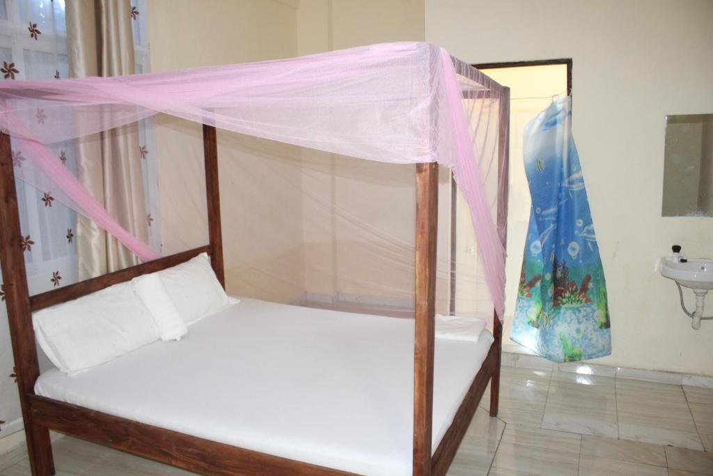 a bed with a canopy in a room at Booster Villa Mtwapa in Mtwapa