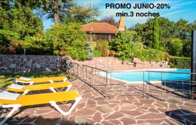 um grupo de espreguiçadeiras amarelas ao lado de uma piscina em Villa Urbasa em San Sebastián