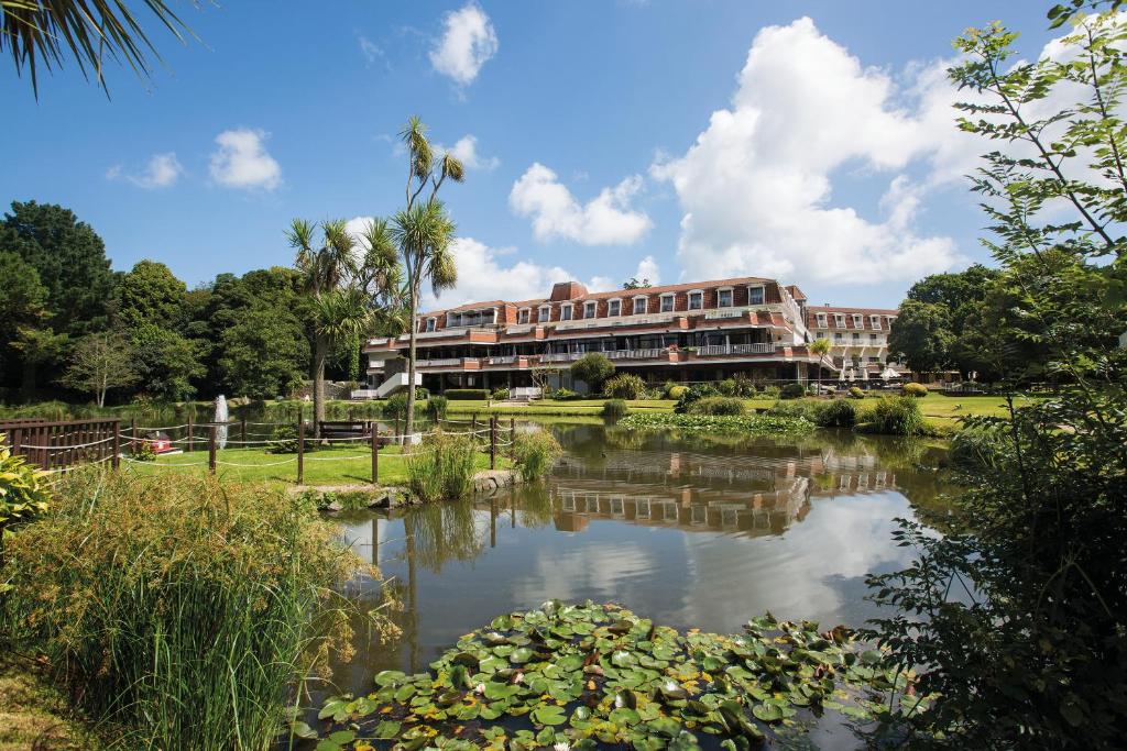 un hotel con un estanque frente a un edificio en St. Pierre Park Hotel & Golf, en St. Peter Port