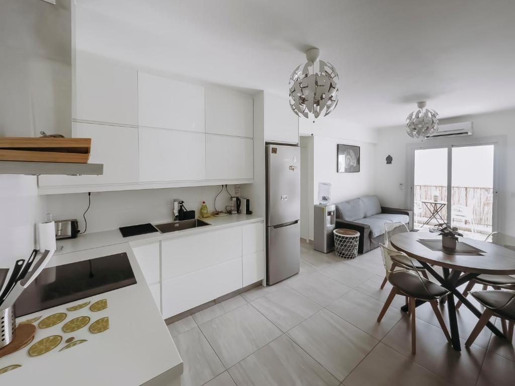 a kitchen with white cabinets and a table and a dining room at Viking Family Superior Lux in Ayia Napa
