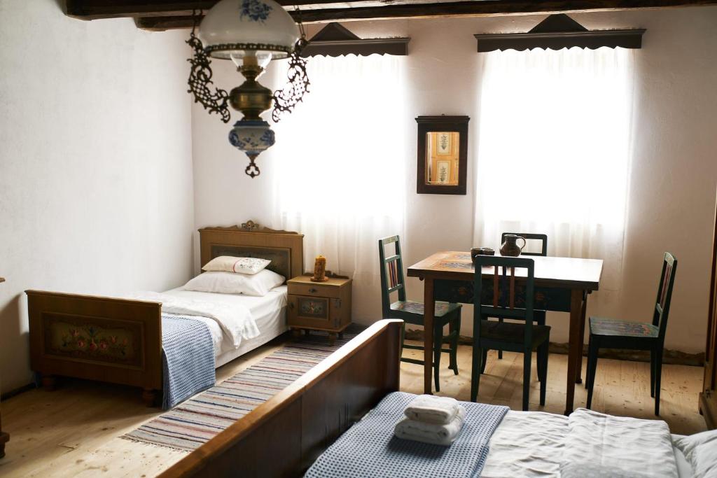 a bedroom with two beds and a table and a desk at Casa Klein- întreaga locație in Meşendorf