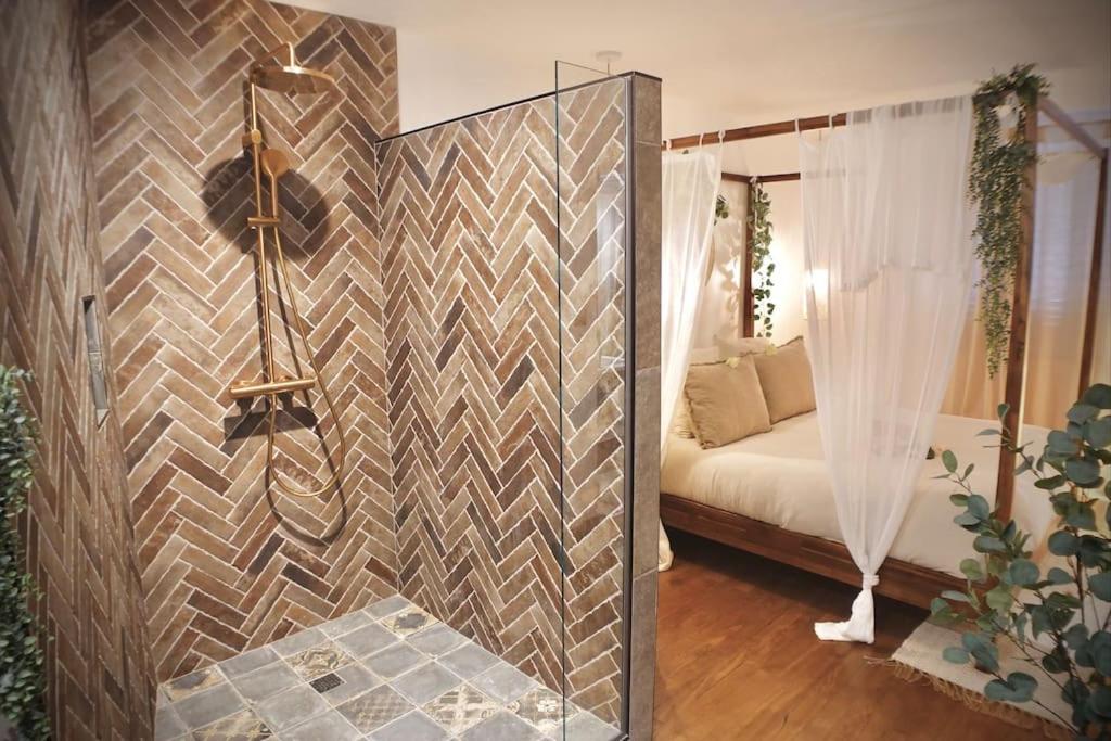 Cette chambre comprend un lit et un mur avec un miroir. dans l'établissement BALI DREAM, pour une escapade inoubliable!, à Grenoble