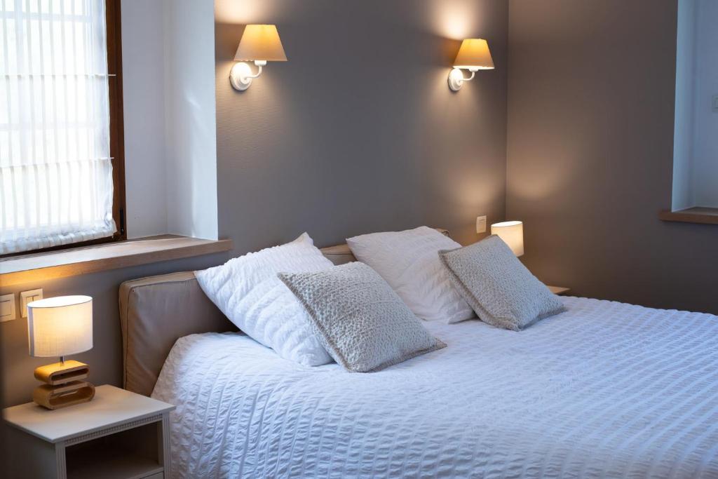 sypialnia z łóżkiem z białą pościelą i poduszkami w obiekcie Sechex Nous w mieście Margencel
