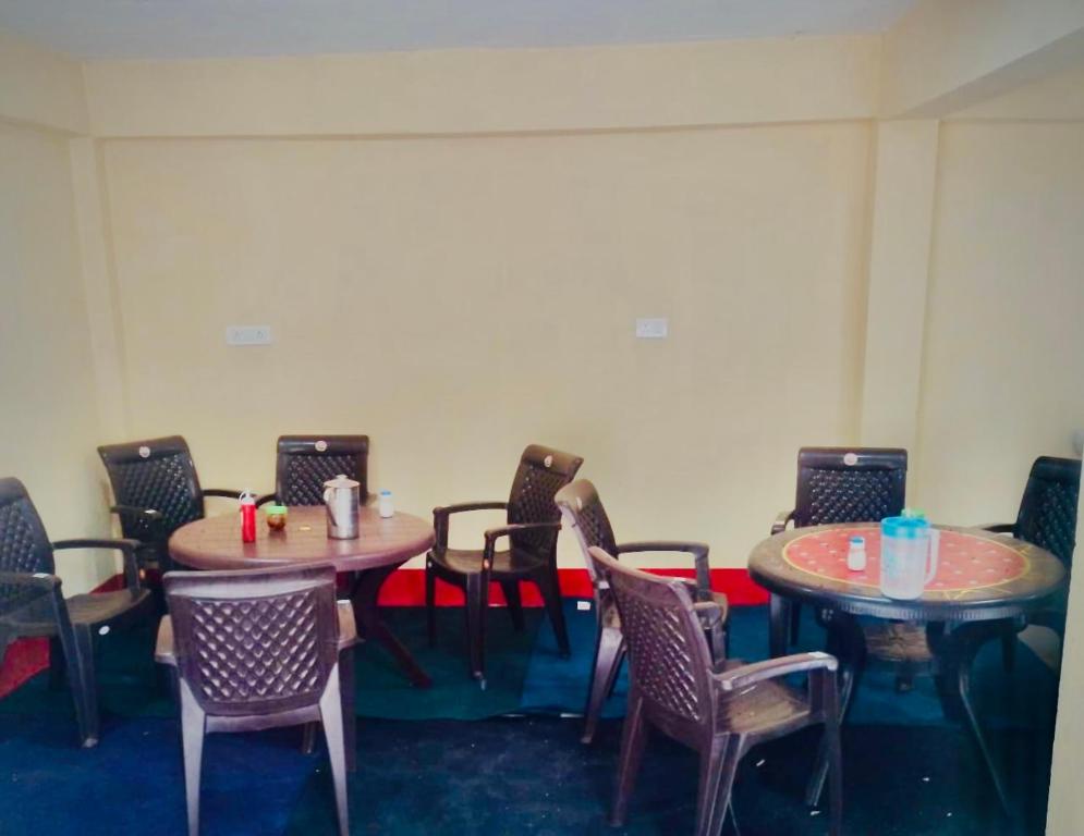 ein Zimmer mit 2 Tischen, Stühlen und einem Tisch in der Unterkunft KAUSHALYADHAM MUNSYARI in Munsyari