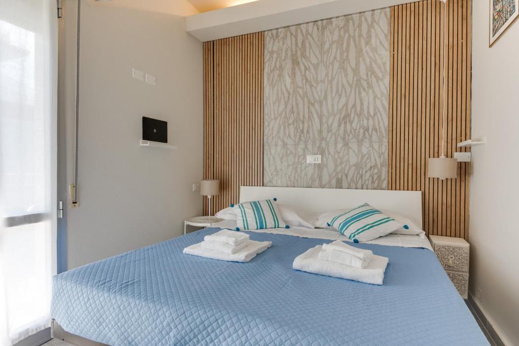 een slaapkamer met een blauw bed met 2 handdoeken erop bij B&B Villa Madana in Rimini