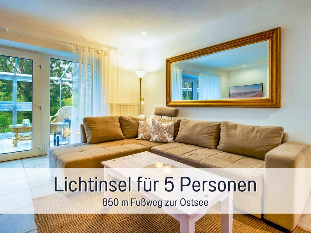 a living room with a couch and a mirror at Ferienwohnung Lichtinsel - strandnah, ebenerdig, haustierfreundlich, großer Garten, optimal für Familien in Steinberg
