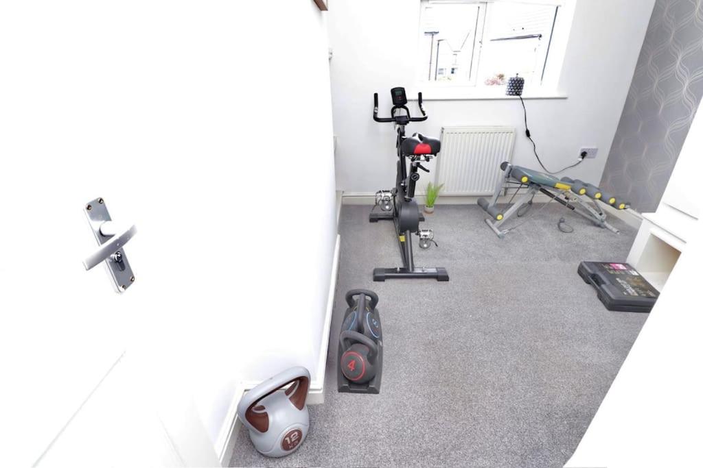 una habitación con un gimnasio con cinta de correr y equipo de ejercicios en contractors house, en Doncaster