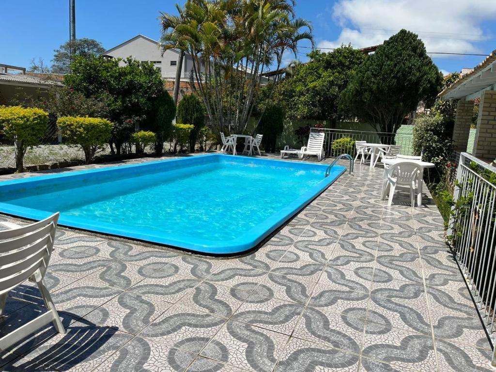 uma piscina num pátio com cadeiras e uma mesa em Pousada o Pelicano Ingleses em Florianópolis