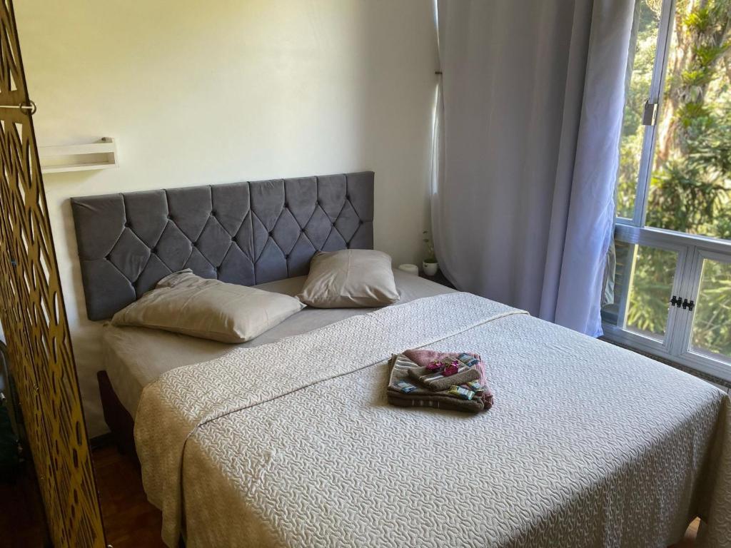 a bedroom with a bed with a large window at ASCB Petrópolis in Petrópolis