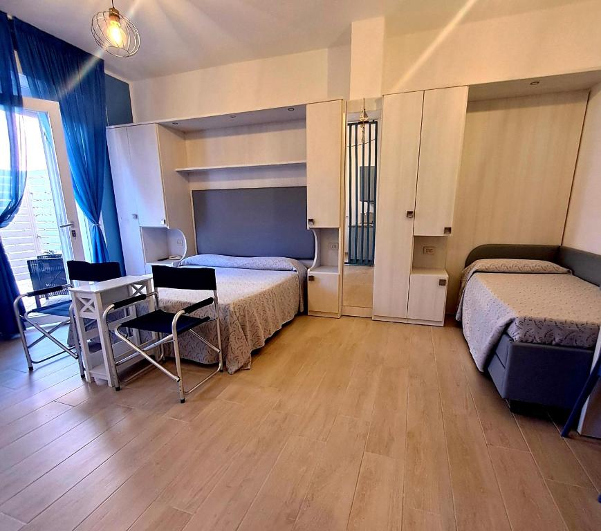 1 dormitorio con 2 camas, mesa y sillas en I Monolocali Del Boccaccio, en Milano Marittima