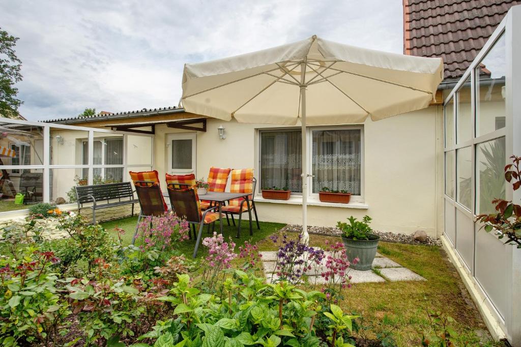 un patio con una sombrilla en un jardín en Caeser - Ferienwohnungen Zinnowitz, en Zinnowitz