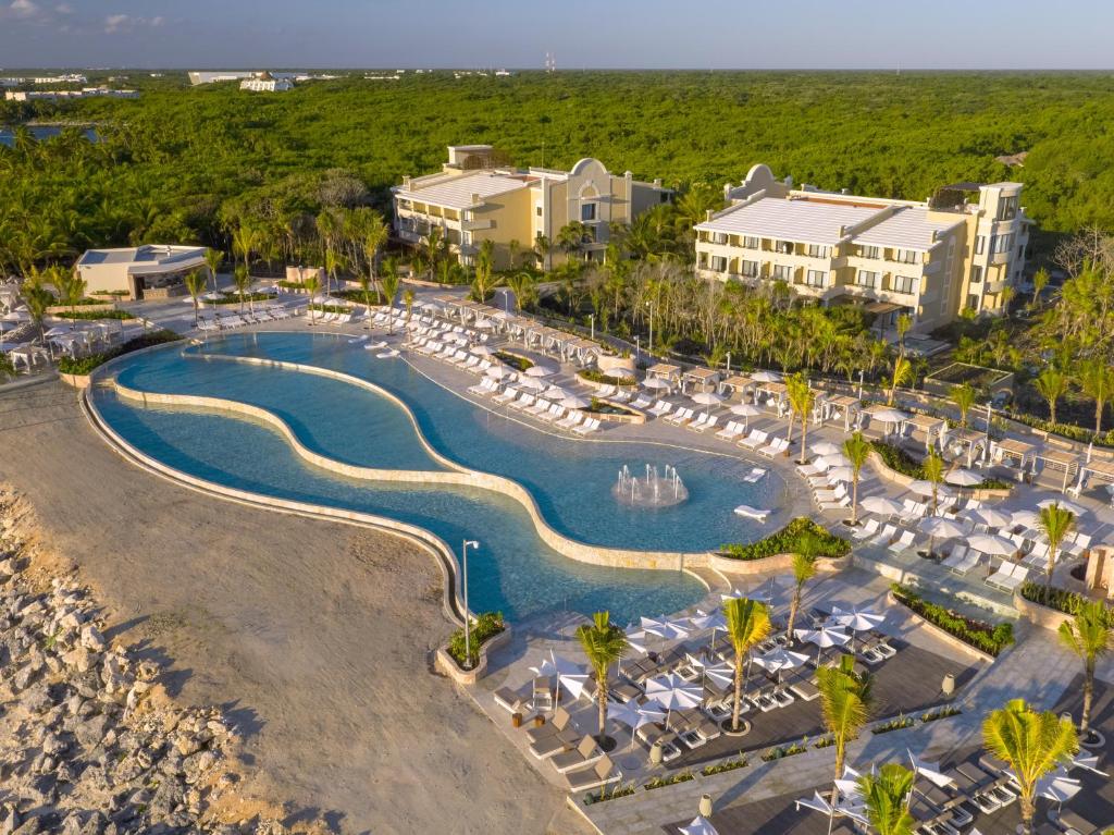 TRS Yucatan Hotel - Adults Only في أكومال: اطلالة جوية على منتجع مع مسبح