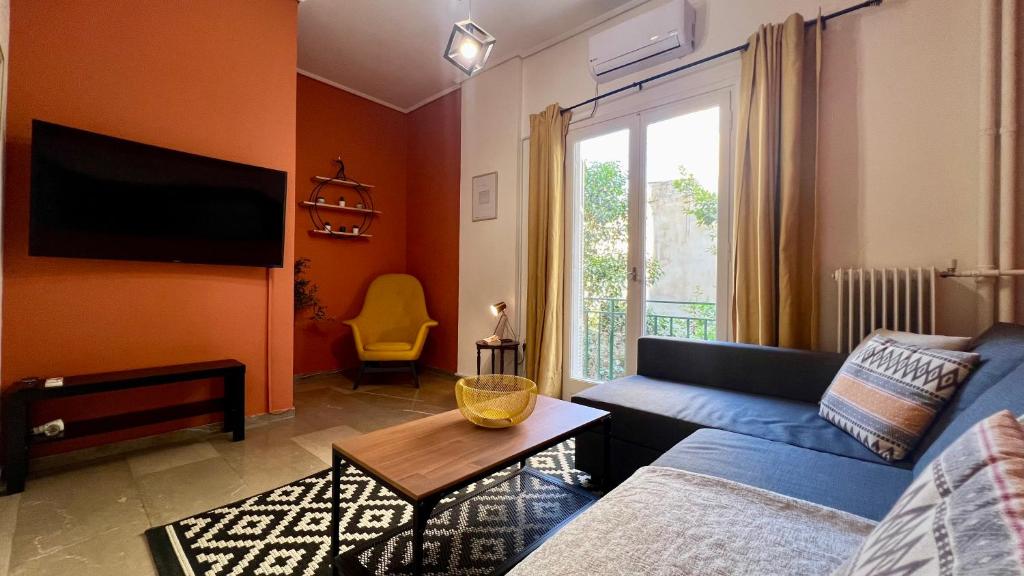uma sala de estar com um sofá azul e uma janela em Modern & Cozy 51sqm Apt in Thisseio em Atenas