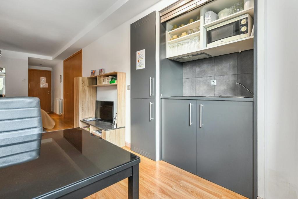 a kitchen with gray cabinets and a black table at Studio at Arinsal 100 m away from the slopes with wifi in Arinsal