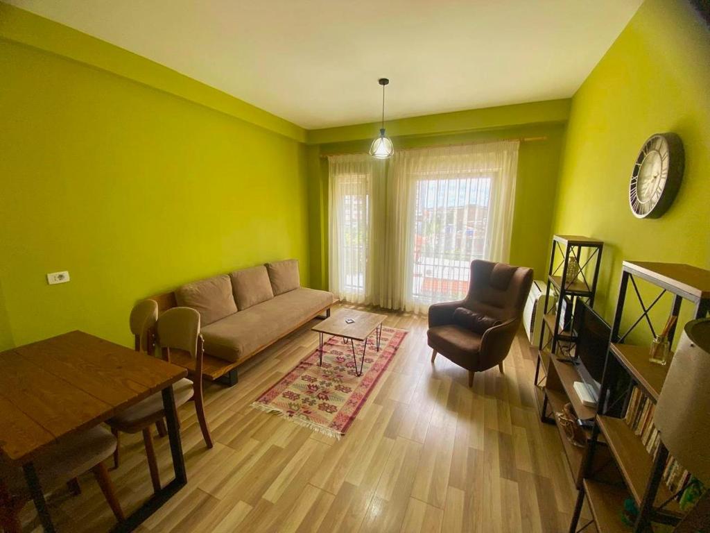 ein Wohnzimmer mit einem Sofa und einem Tisch in der Unterkunft Cozy Stay Apartment in Tirana