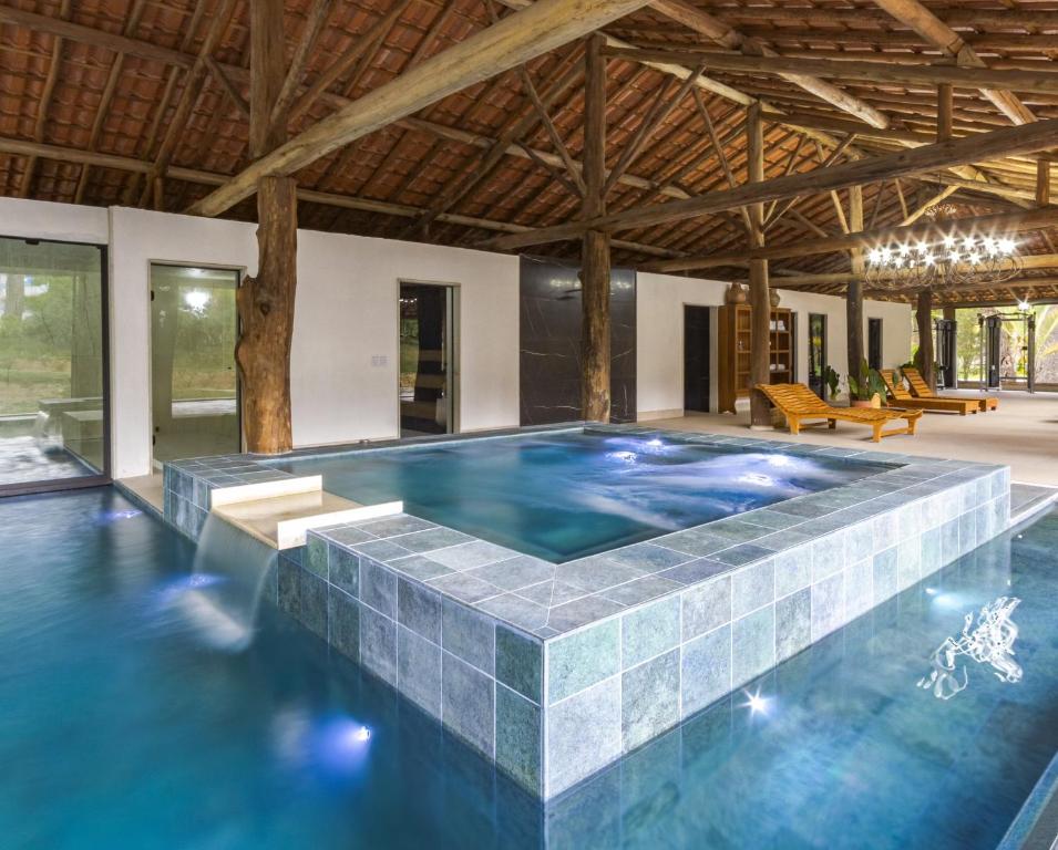 an indoor swimming pool with a tile floor and ceiling at Resort Fazenda 3 Pinheiros in Engenheiro Passos