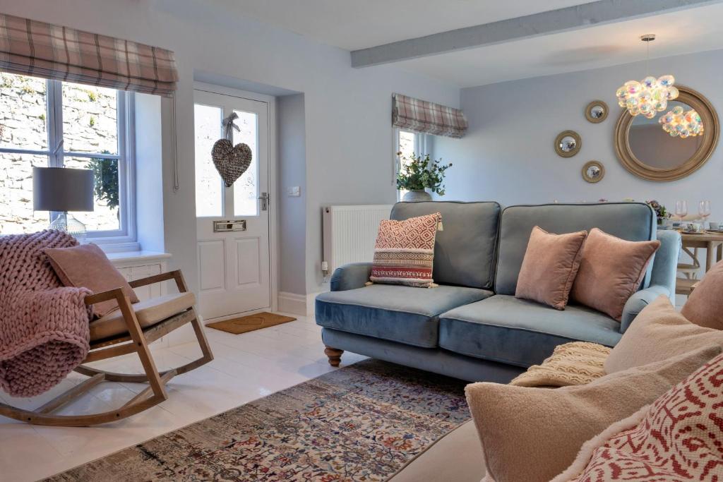 a living room with a blue couch and a chair at Finest Retreats - Sisu Bakewell, Limestones Cottage in Bakewell
