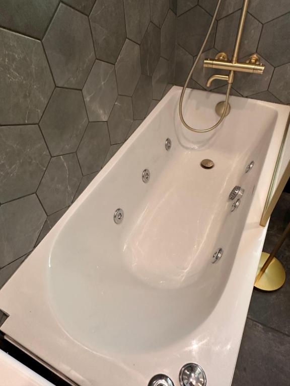 爱丁堡Wee one Flat share accomodation的浴室里有水龙头的白色浴缸