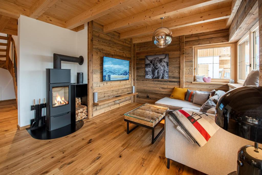 un salon avec cheminée dans une cabane en rondins dans l'établissement Filzsteinresort Chalets Chalet Bergankunft 236, à Krimml