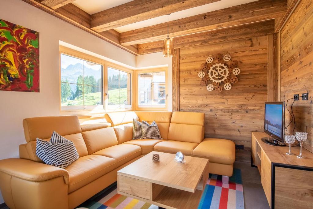 un salon avec un canapé et une table dans l'établissement Filzsteinresort Chalets - Chalet 238, à Krimml