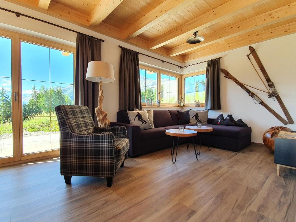 un salon avec un canapé et une chaise dans l'établissement Filzsteinresort Chalets - Chalet 240, à Krimml