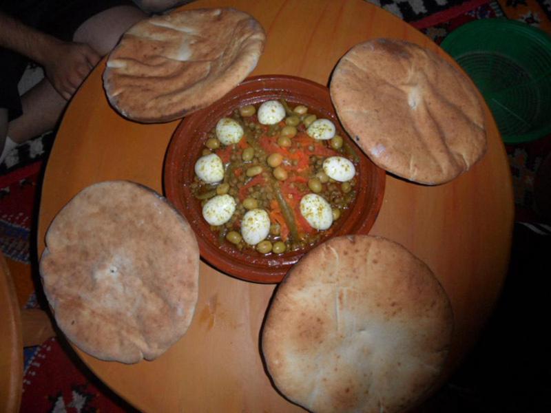 a table with a bowl of food and some bread at Gite Ifoulou Tassaout in Ifoulou