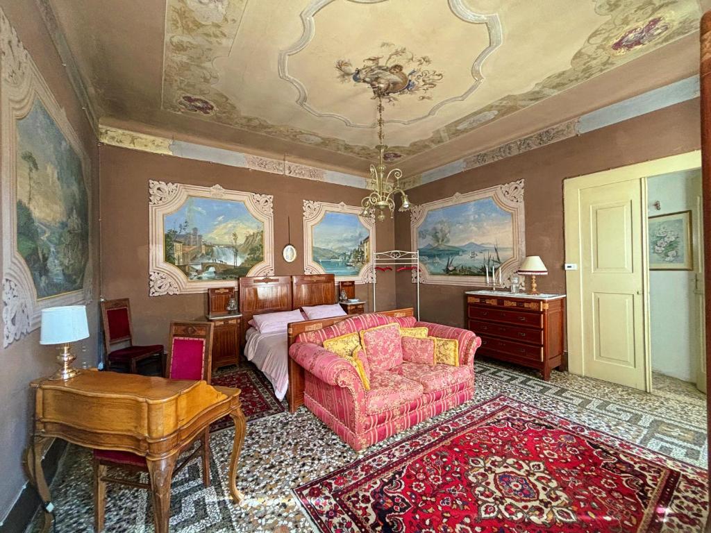 a bedroom with a bed and a couch and a table at Palazzetto Scodellari in San Vito al Tagliamento