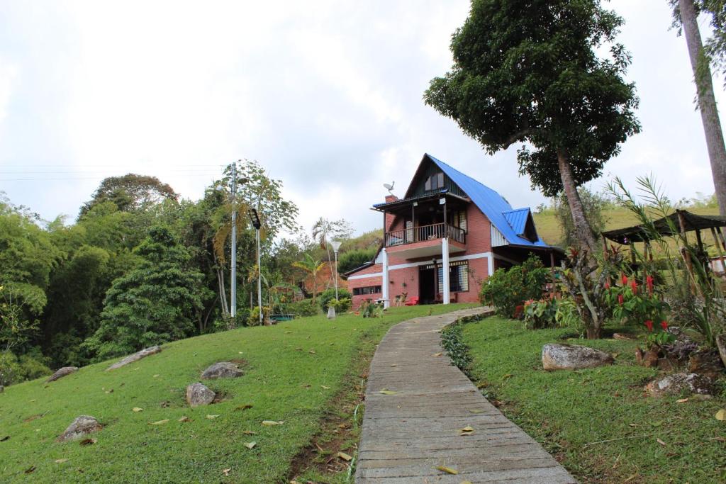 a house on a hill with a path leading to it at Finca Lago Calima in Yotoco