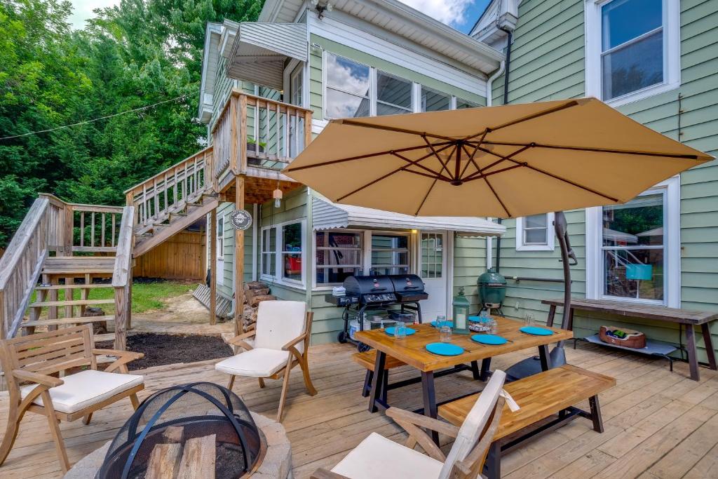 un patio con un tavolo e un ombrellone di 4 Mi to Liberty U Huge Home with Yard and Hot Tub a Lynchburg