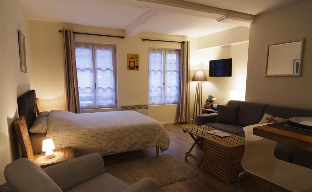 une chambre avec un lit et un salon avec un canapé dans l'établissement Le Studio du Gouverneur, à Honfleur